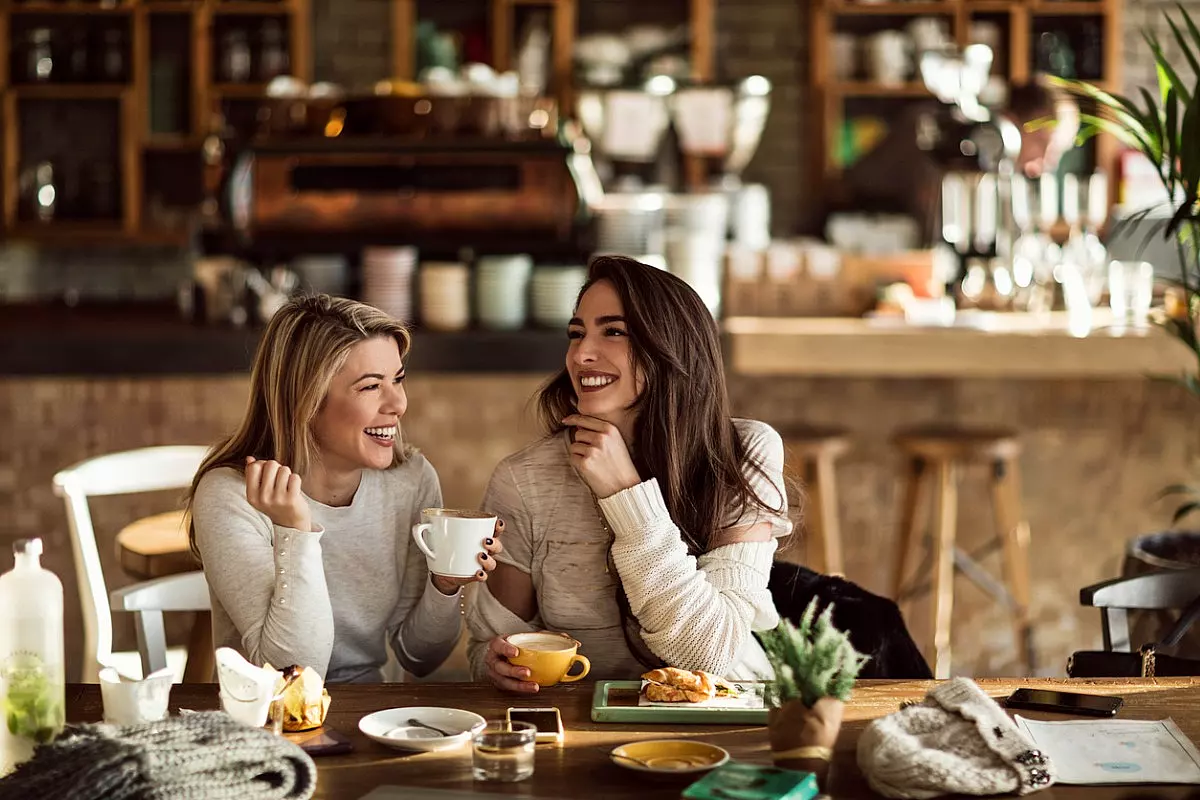 Due donne felici si divertono ad un caffè al bar