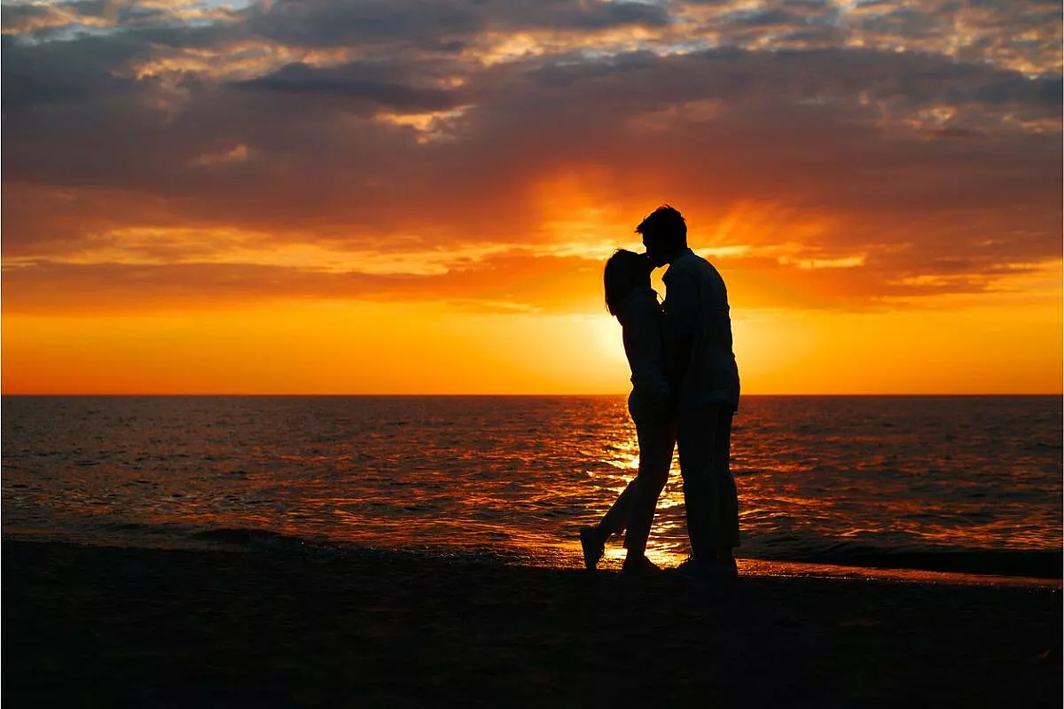 Immagine romantica di una coppia che si bacia in un tramonto sul mare