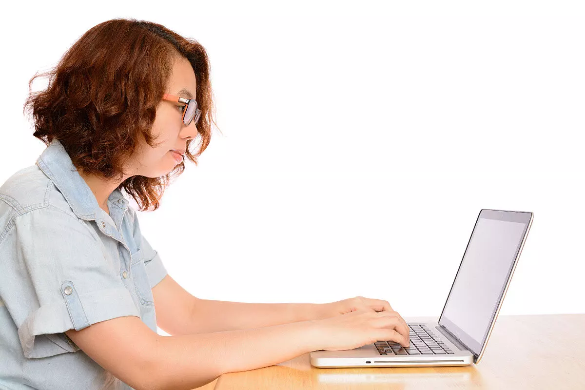 Donna in posizione scorretta davanti ad un laptop
